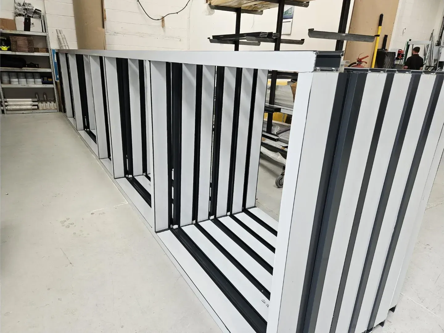 Aluminium curtain wall and shopfront sections taped and staged in the workshop