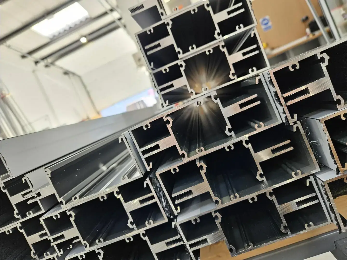 Cut aluminium door and frame profile sections in the Kingsland workshop — the cross-section helps identify a door system