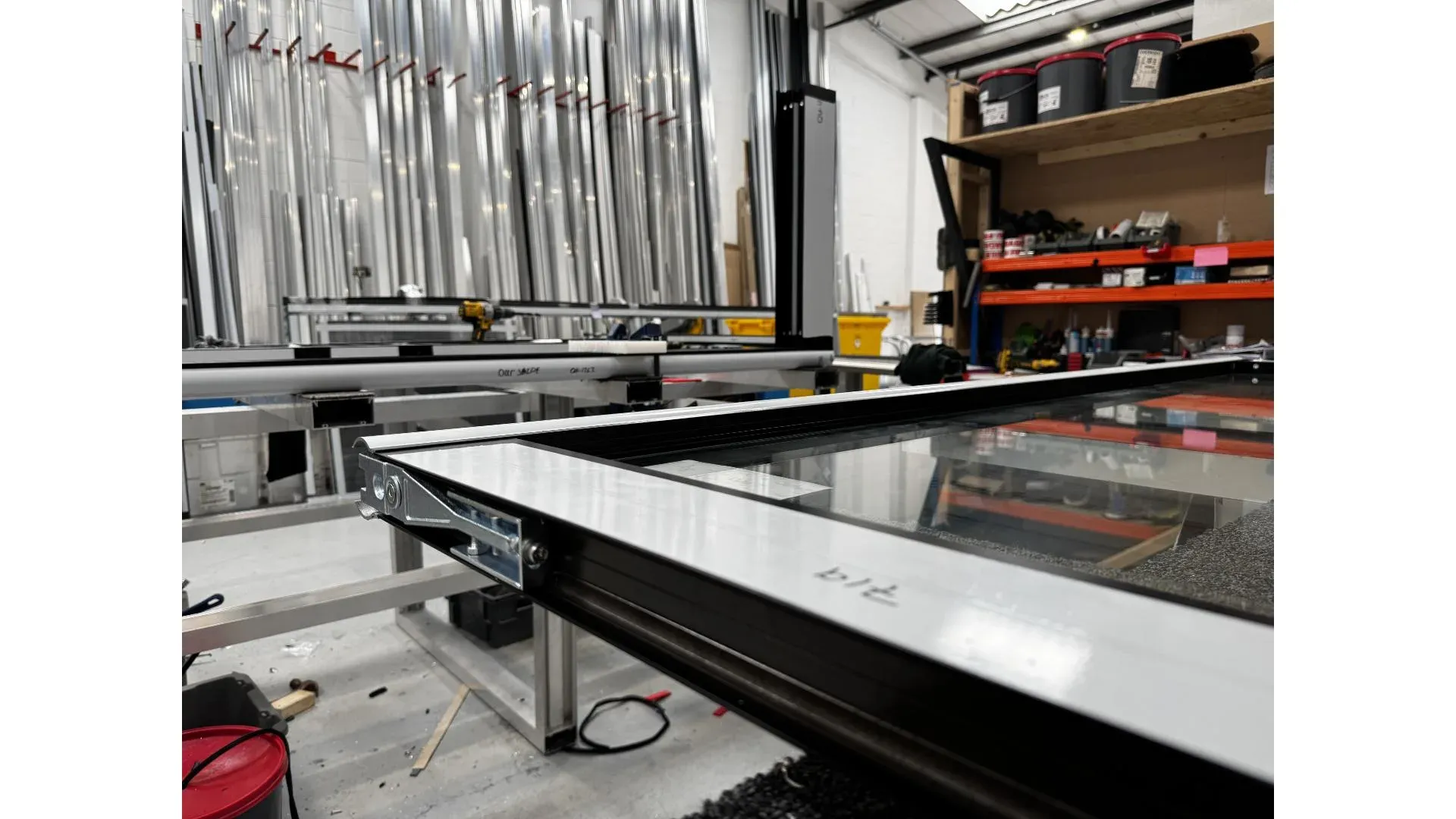 Window frame on assembly jig with hardware being fitted